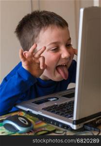 Joking Child in Front of Touch Screen Laptop, tongue stuck out