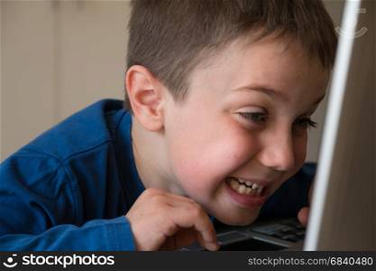 Joking Child in Front of Touch Screen Laptop, tongue stuck out