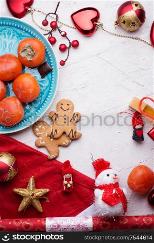 jolly traditional Christmas set with gifts and fruits around white background. flat lay