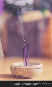 Joss sticks in smoking bowl are smoking and smelling, home, feng shui; Copy space;