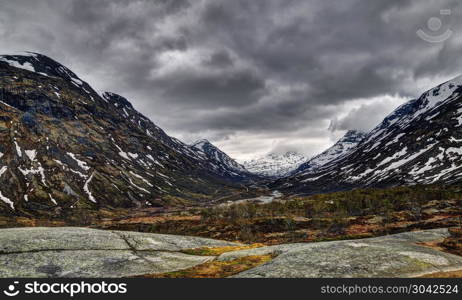 Jotunheimen National park. Gloomy day, 55 tourist road in Norway. Snow, stratus cloudy and wind in may. Jotunheimen National Park