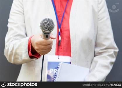 Journalist holding microphone and making media interview