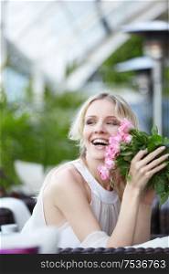 Joyful attractive girl with flowers in the restaurant