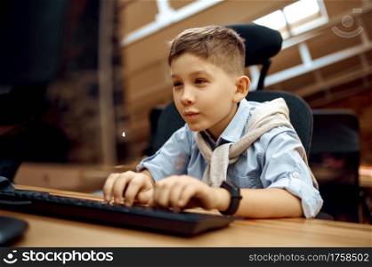Joyful boy works on PC, little blogger. Kid blogging in home studio, social media for young audience, online internet broadcast, creative hobby. Joyful boy works on PC, little blogger