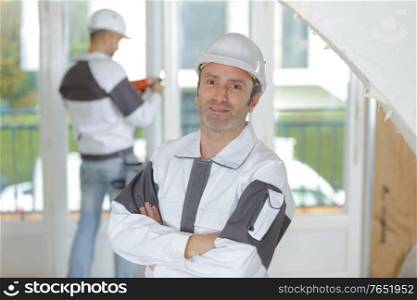 joyful builder smiling while standing indoors