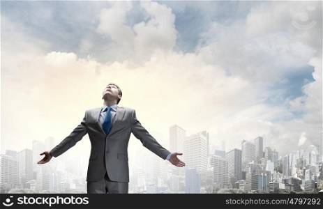 Joyful businessman with outstretched arms celebrating success