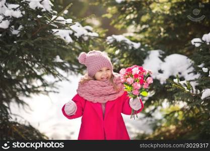 Joyful child in the winter forest with a bouquet of flowers.. Happy girl with a bouquet of carnations for mom 929.. Happy girl with a bouquet of carnations for mom 929.