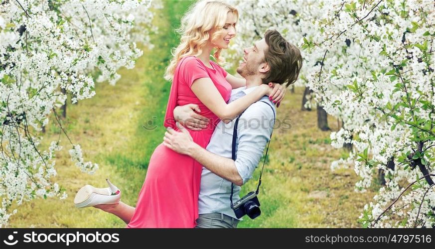 Joyful couple in the fragrant apple orchard