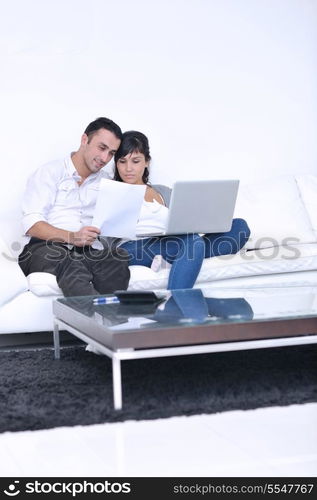 joyful couple relax and work on laptop computer at modern living room indoor home