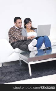 joyful couple relax and work on laptop computer at modern living room indoor home