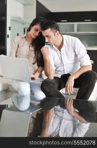 joyful couple relax and work on laptop computer at modern living room indoor home