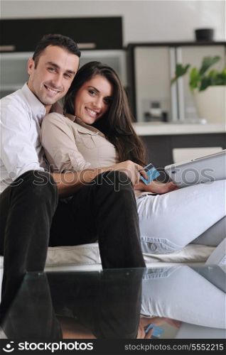 joyful couple relax and work on laptop computer at modern living room indoor home