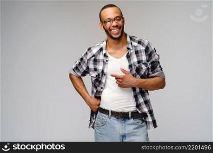 Joyful friendly african-american young man iwearing casual shirt pointing by finger at copy space.. Joyful friendly african-american young man iwearing casual shirt pointing by finger at copy space