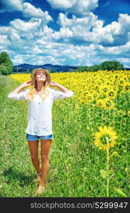Joyful girl walking in sunflowers field, active lifestyle, agricultural landscape, enjoying blooming nature, autumn season concept