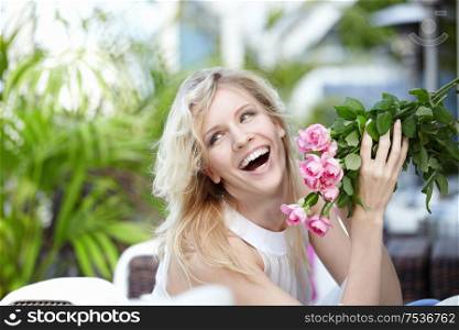 Joyful girl with flowers in a cafe