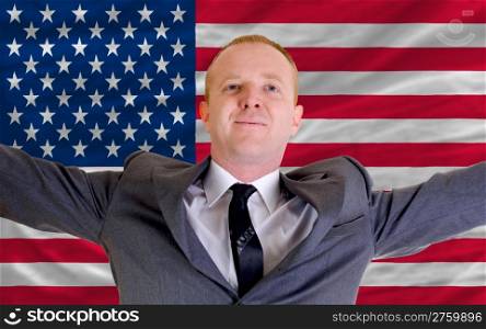 joyful investor spreading arms after good business investment in america, in front of flag
