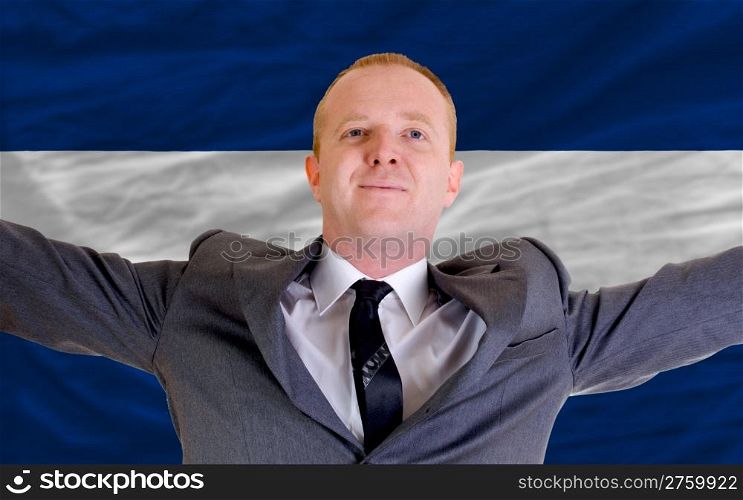 joyful investor spreading arms after good business investment in nicaragua, in front of flag