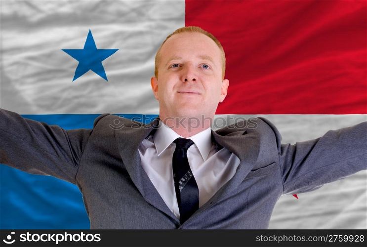 joyful investor spreading arms after good business investment in panama, in front of flag