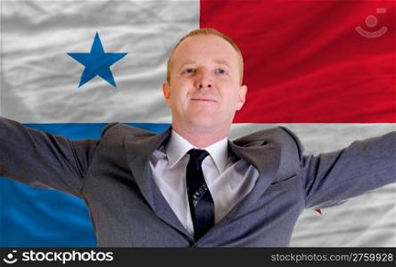 joyful investor spreading arms after good business investment in panama, in front of flag