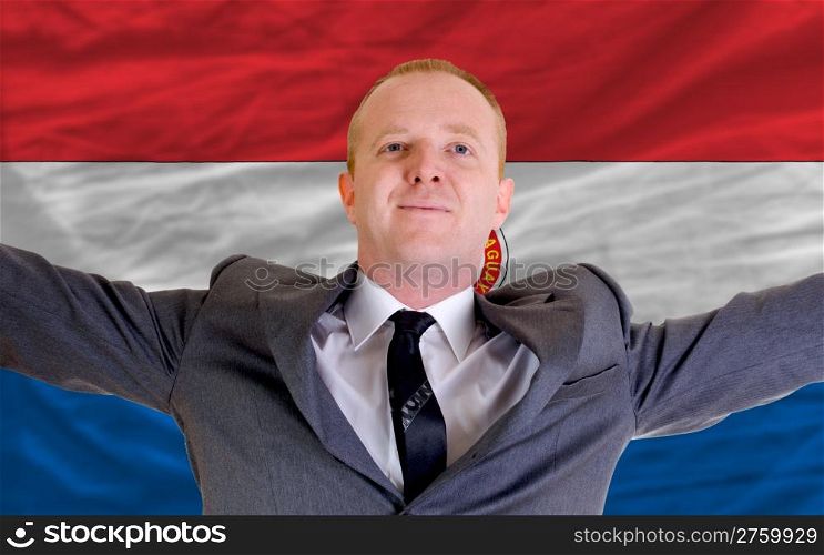 joyful investor spreading arms after good business investment in paraguay, in front of flag