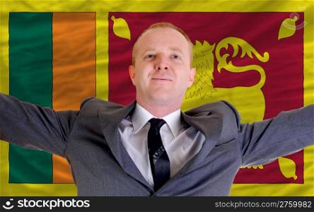 joyful investor spreading arms after good business investment in srilanka, in front of flag