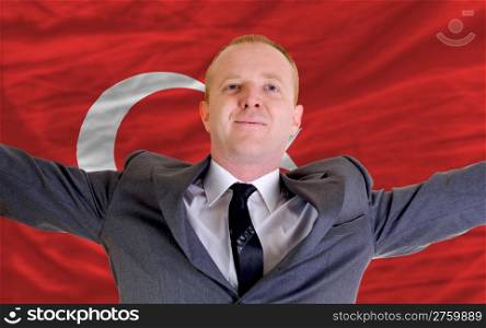 joyful investor spreading arms after good business investment in turkey, in front of flag