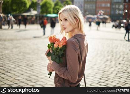 Joyful lady holding a bouquet of fresh red roses