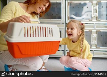 Joyful mother and girl child feeling happy after buying cat at shop. Woman and girl with cat carrier. Cheerful new pet owners. Joyful mother and girl child feeling happy after buying cat at shop