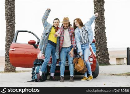 joyful people taking selfie near red car