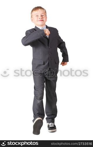 joyful schoolboy wearing accurate suit is walking. isolated.