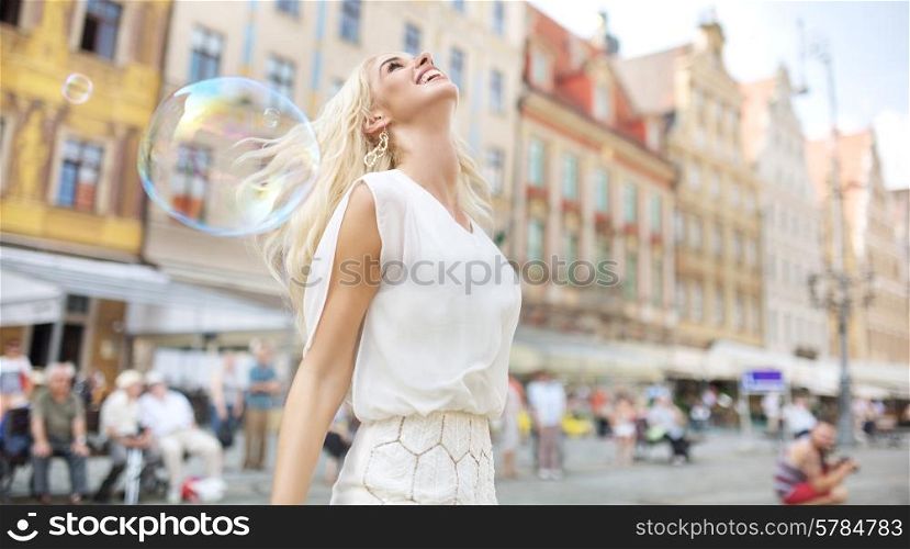 Joyful woman among the soap bubbles