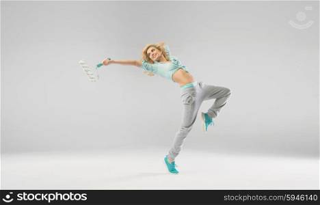Joyful woman exercising with paint roller