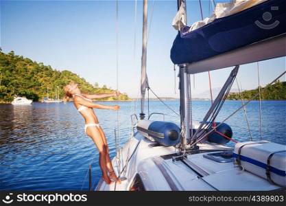 Joyful woman on sailboat, female with perfect body tanning and enjoying luxury summer vacation, active people lifestyle