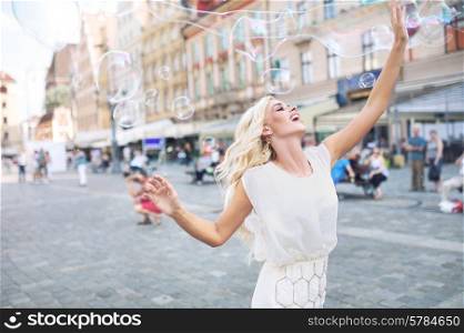 Joyful woman playing the soap bubbles