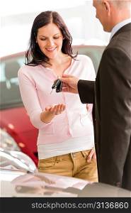 Joyful woman receiving the keys of her new car