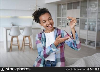 Joyful young african american woman showing house keys at new home. Biracial teen girl homeowner, tenant feels happiness with relocation or purchase of flat. Real estate rent, first own apartment.. Joyful teen girl homeowner, tenant holds keys to new house. Real estate rent, first own apartment
