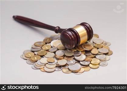 judges law gavel on pile of coins isolated on gray