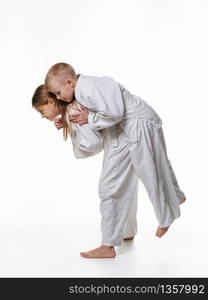 Judo student girl learns to perform throw through the thigh