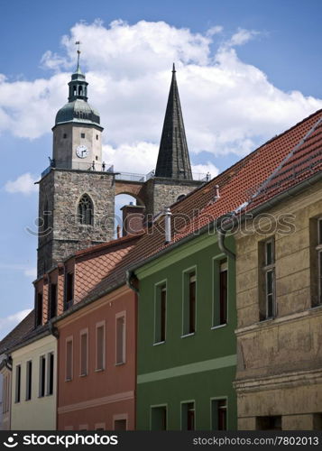 Jueterbog-Nikolaikirche-Hausfassaden. towers of st. nicholas church in Jueterbog behind facades