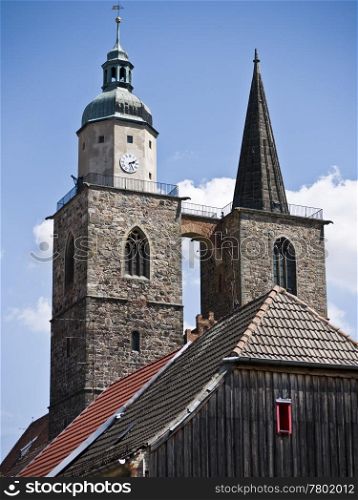 Jueterbog-Nikolaikirche. towers of st. nicholas church in Jueterbog behind the gable of an old house