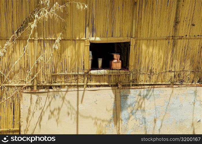 Jug and cup in the window of a thatched hut, Pushkar, Rajasthan, India