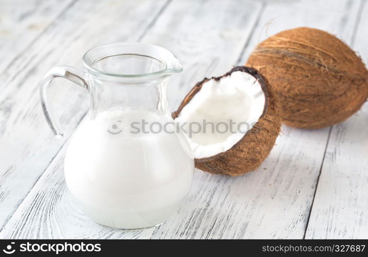 Jug of coconut milk with fresh coconut