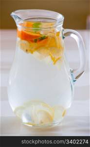 Jug of cold water with lemon and orange slices