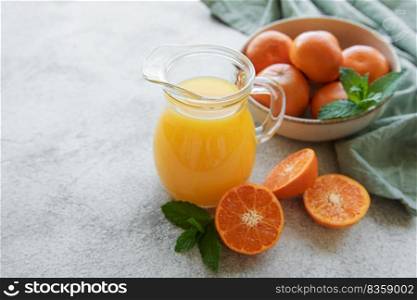 Jug of fresh orange tangerine juice with fresh fruits