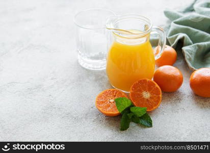 Jug of fresh orange tangerine juice with fresh fruits