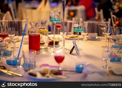 Jugs with lemonade and glasses on table at wedding party or banquet. Glasses and jugs with drinks setting on the festive table in restaurant.