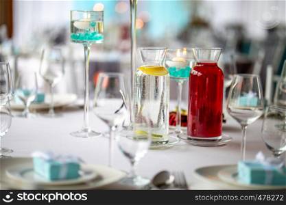 Jugs with lemonade on table with food at wedding party or banquet. Water with fresh lemon and red limonade on the table. Focus on jug with water.