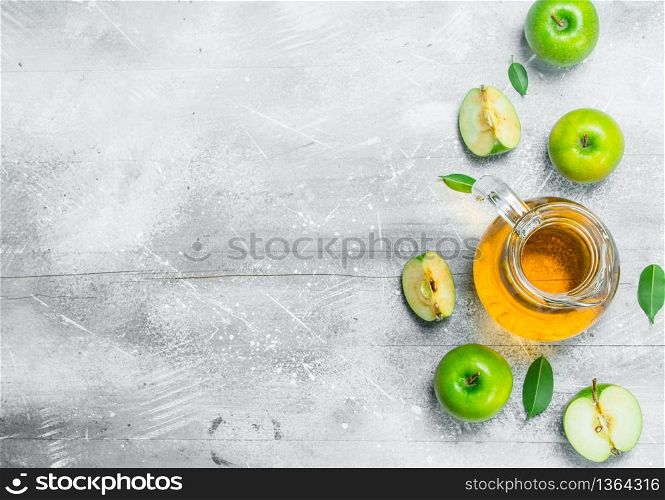 Juice and fresh apples in a glass jar with slices of apples. On white rustic background.. Juice and fresh apples in a glass jar with slices of apples.