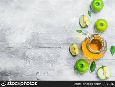 Juice and fresh apples in a glass jar with slices of apples. On white rustic background.. Juice and fresh apples in a glass jar with slices of apples.