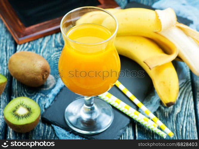 juice from kiwi and banana in the glass and on a table